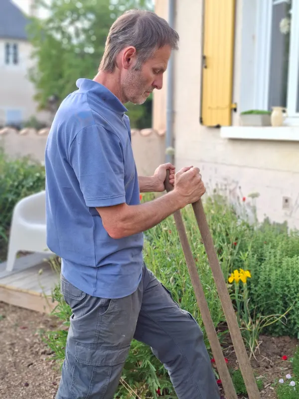 Christophe, Le Potagiste, de profil pendant une intervention dans un jardin devant maison